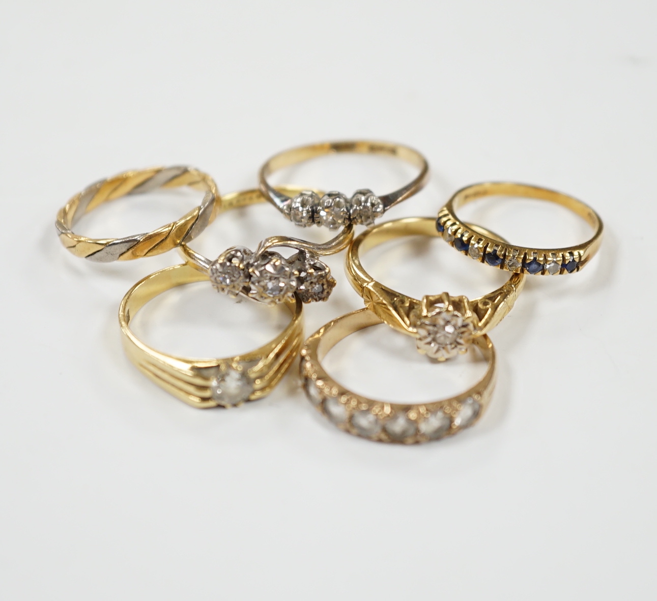 A 1920's 18ct gold and claw set solitaire diamond ring, size O, five other assorted 18ct gold and gem set rings including diamond, together wit a yellow metal and paste set half hoop ring, gross weight 17.2 grams.